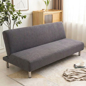 Housse de canapé-lit futon grise en tissu jacquard dans un salon lumineux