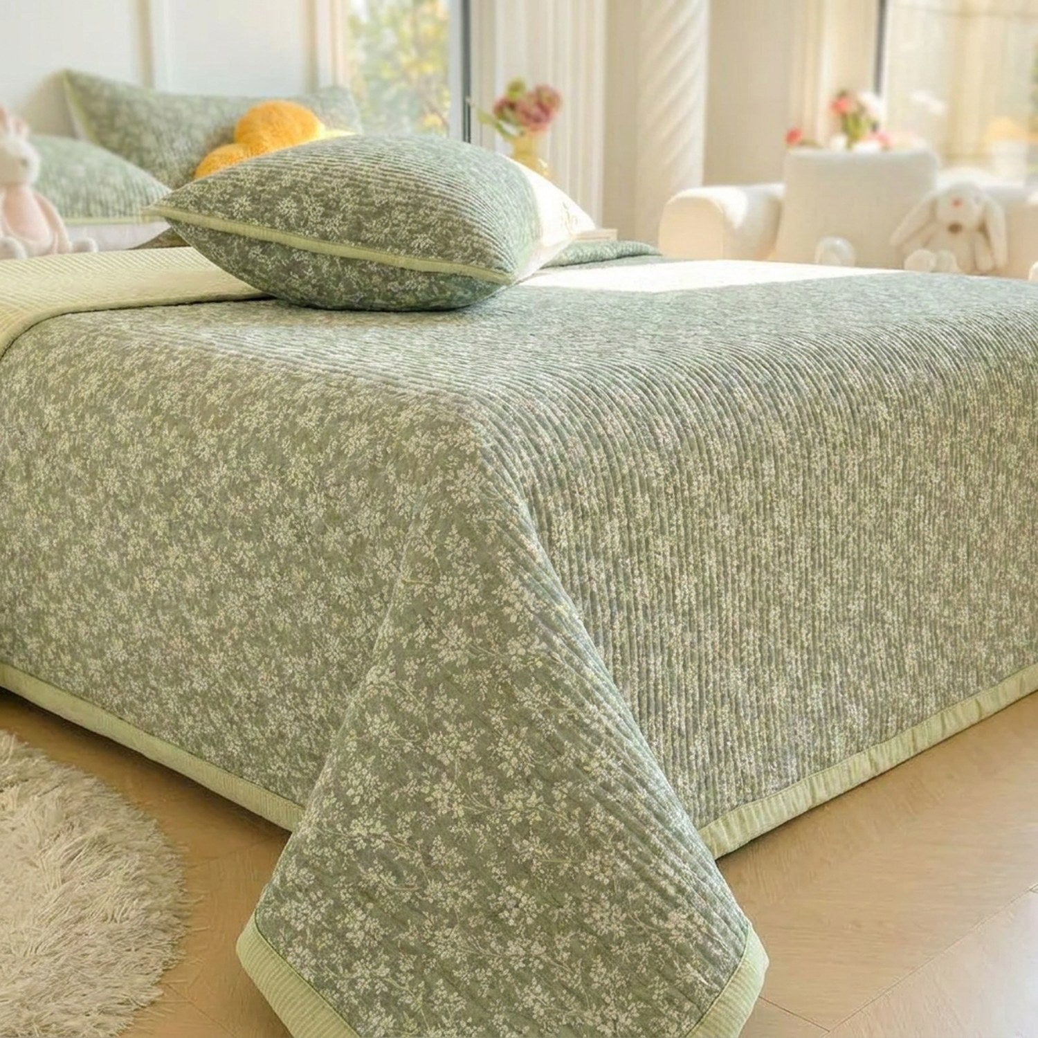Couvre-lit matelassé vert à motifs floraux posé sur un lit fait dans une chambre lumineuse