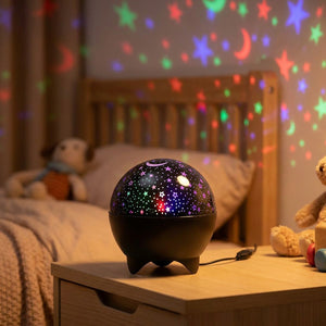 Veilleuse projecteur ciel étoilé noire allumée sur une table de chevet projetant des étoiles colorées dans une chambre d'enfant