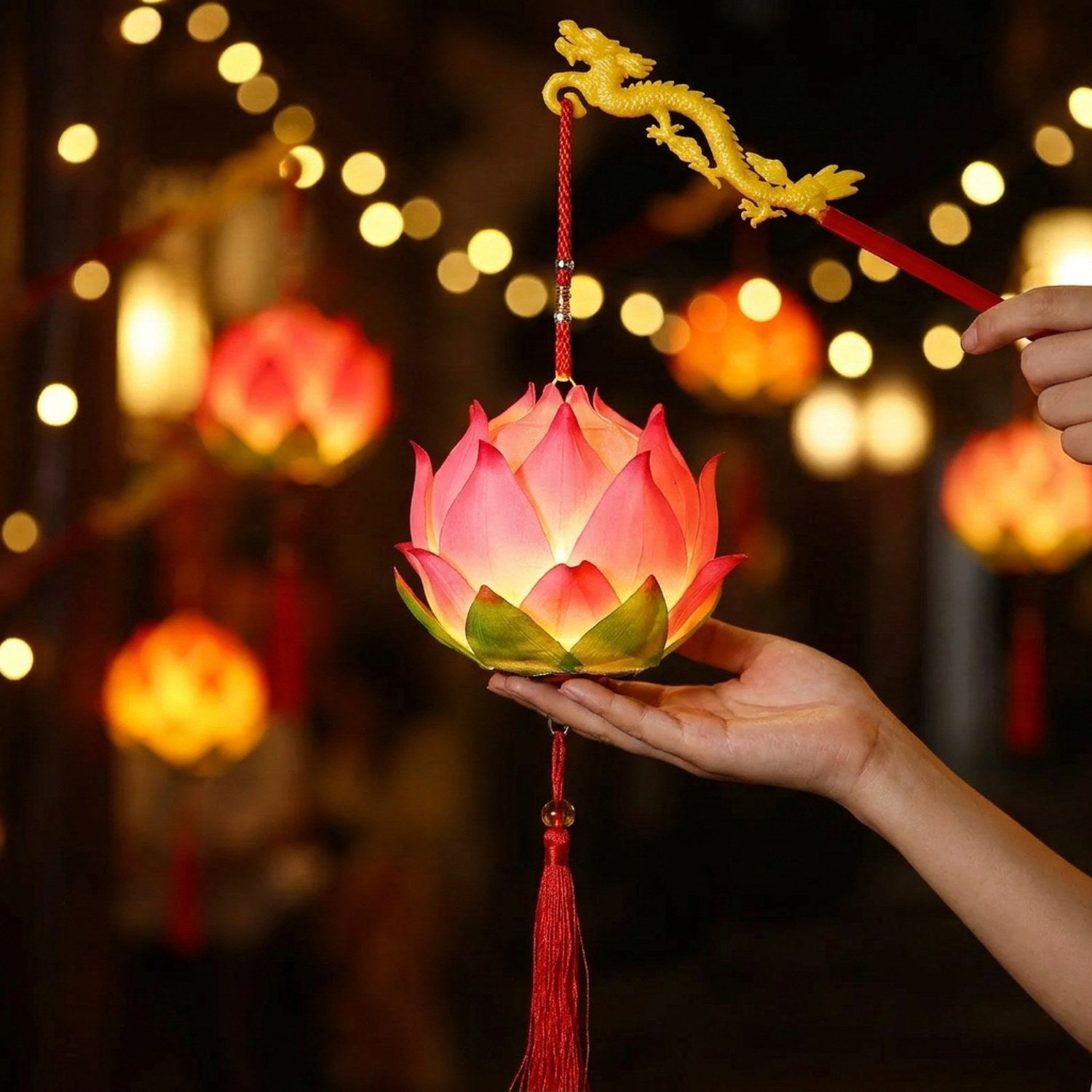 Lanterne lotus rose lumineuse tenue à la main avec poignée dragon doré dans une ambiance chinoise festive