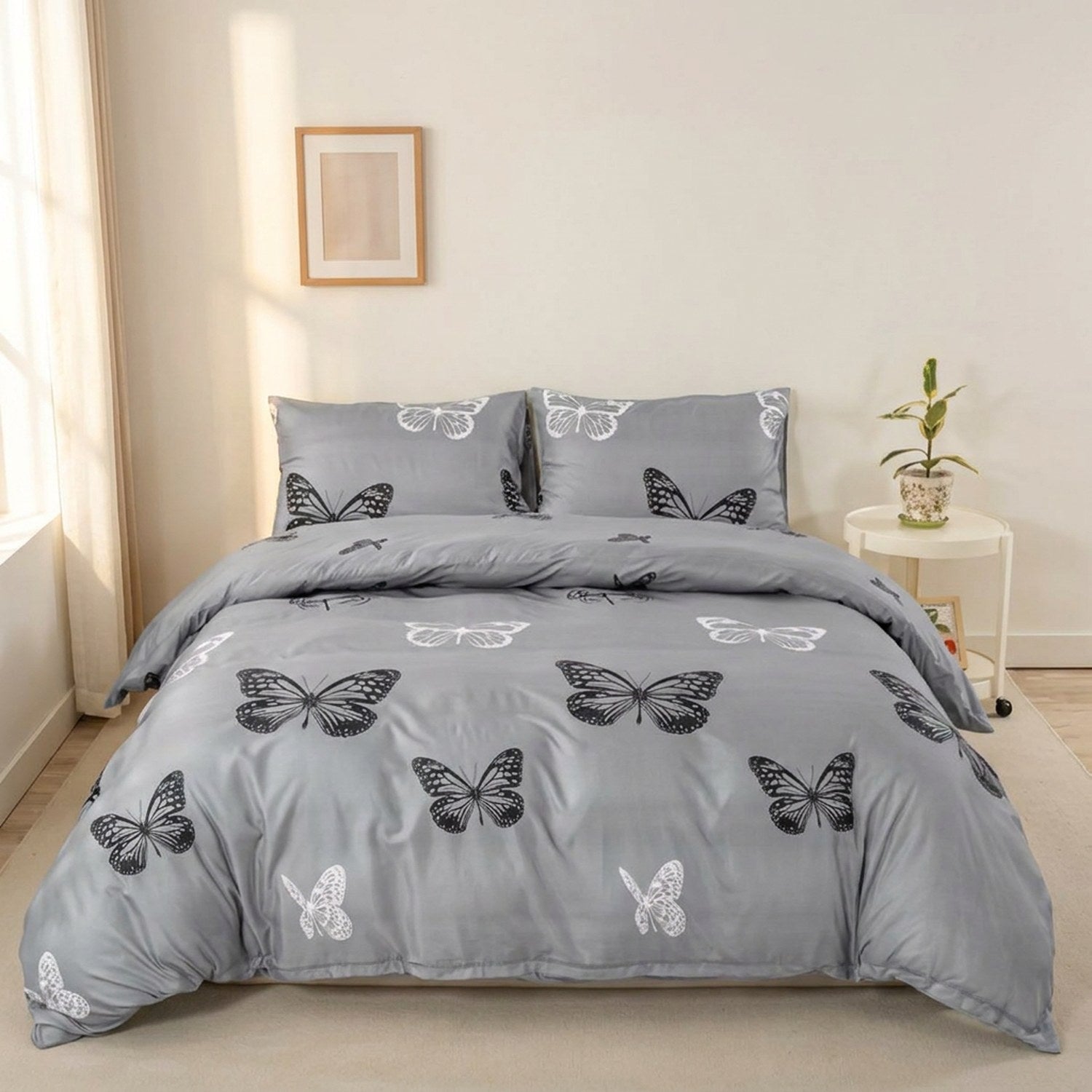 Parure de lit papillon imprimée noir et blanc sur fond gris installée sur un lit dans une chambre lumineuse