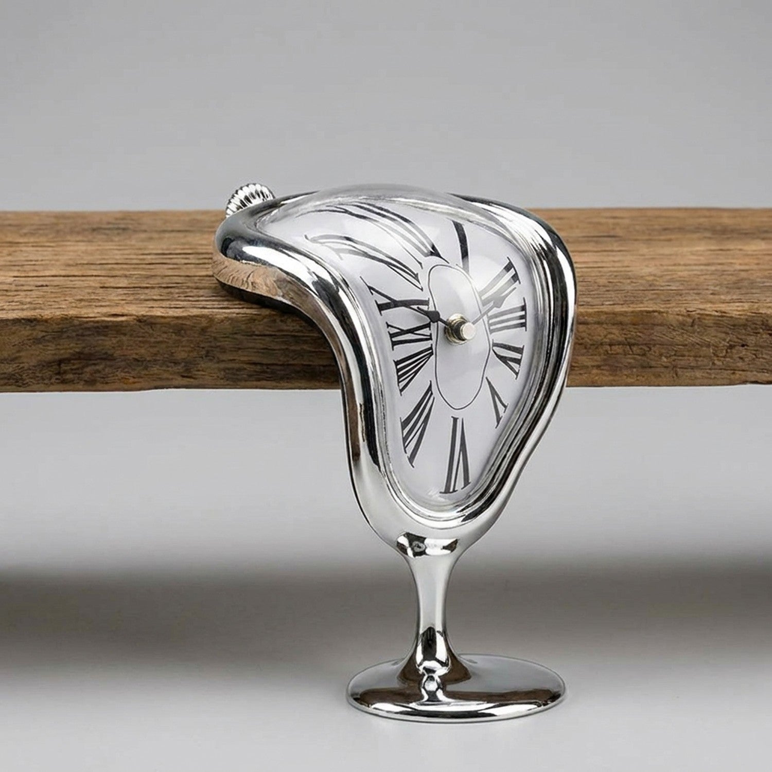Horloge murale surréaliste argentée fondante et déformée sur fond gris neutre
