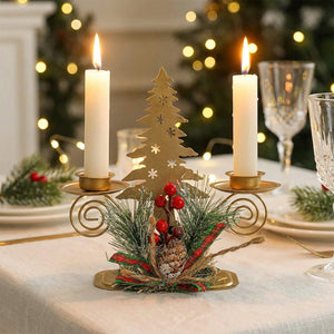 Bougeoir de Noël doré en métal avec décoration sapin ajouré et deux bougies allumées sur table de fête