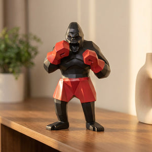 Statue de gorille boxeur noir en résine aux gants rouges posée sur une étagère déco moderne