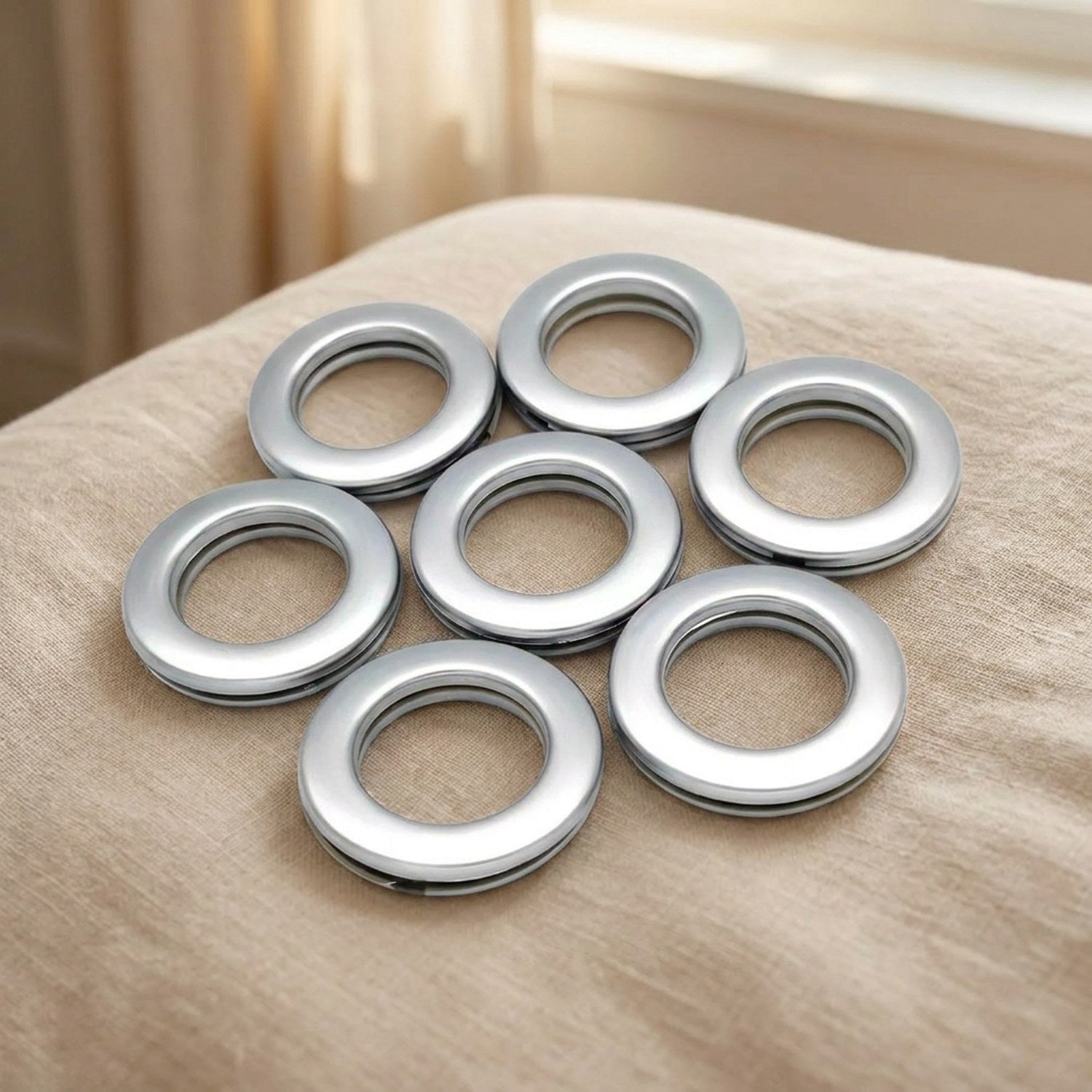 Lot de sept œillets de rideau clipsables en plastique argent mat au fini satiné disposés en cercle