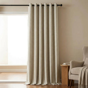 Rideau chenille beige à motif chevrons suspendu devant une fenêtre de salon lumineux