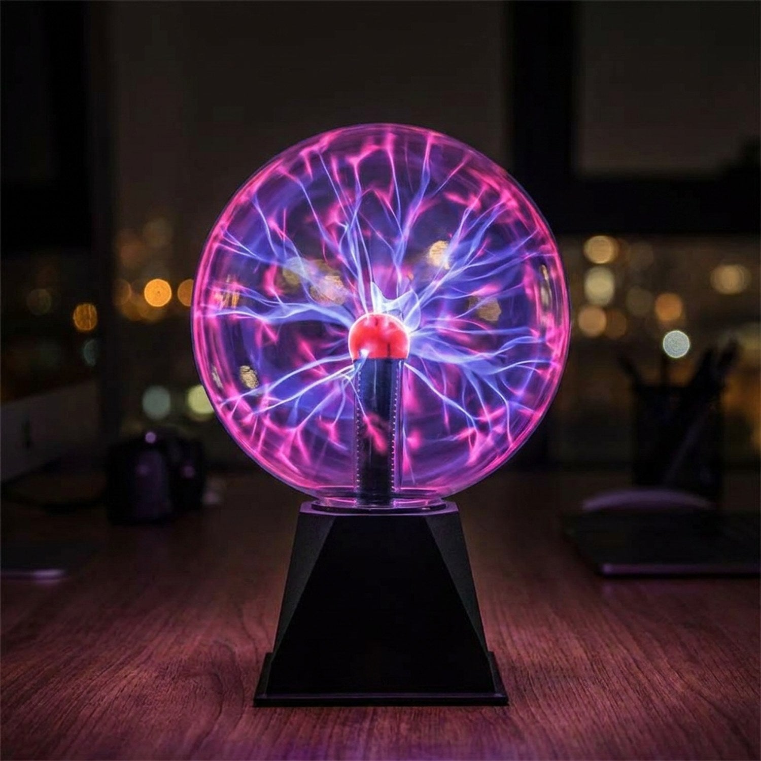 Lampe boule de plasma violette avec éclairs lumineux allumée sur un bureau dans le noir