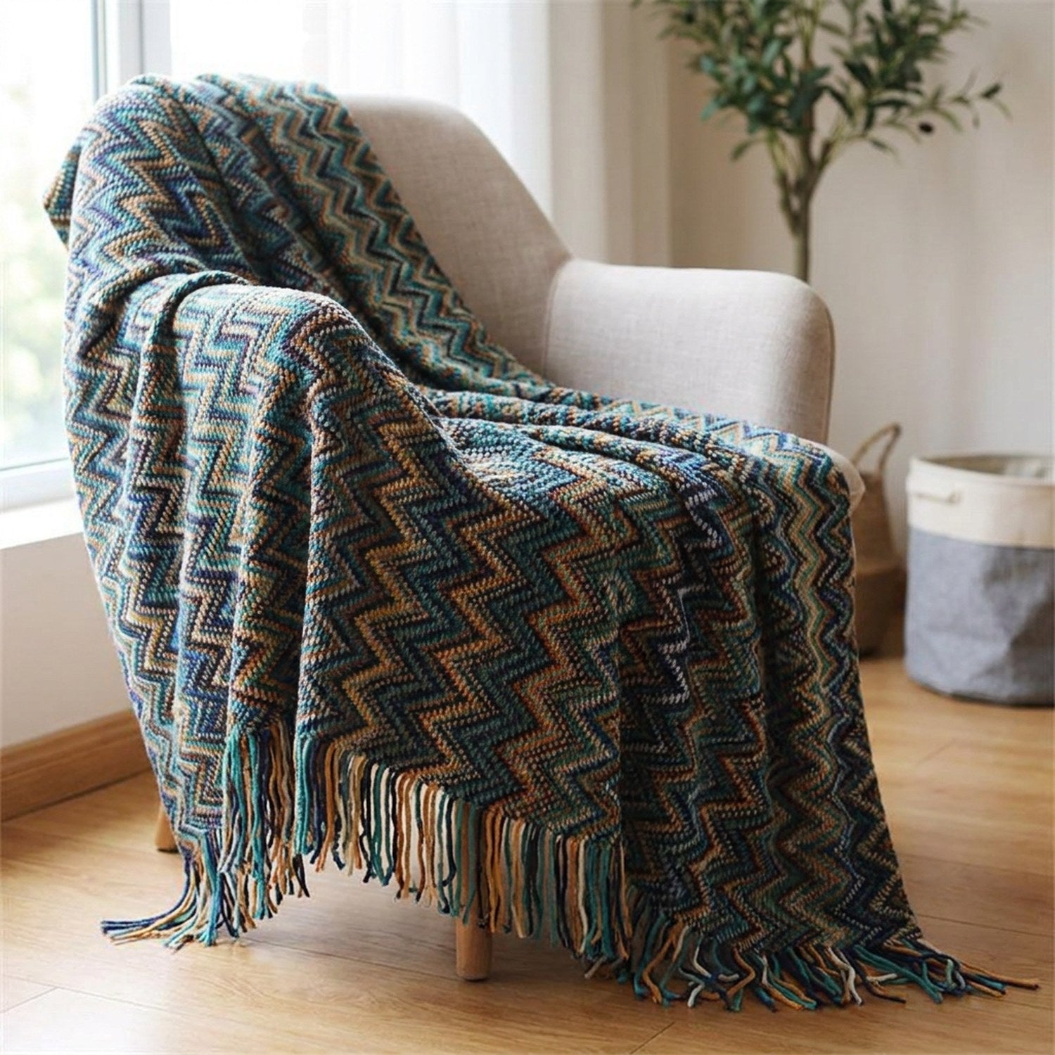 Plaid tricoté à motifs chevrons multicolores et franges drapé sur un canapé bleu