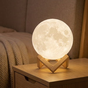 Lampe lune personnalisée posée sur un socle en bois diffusant une lumière chaude dans un intérieur cosy