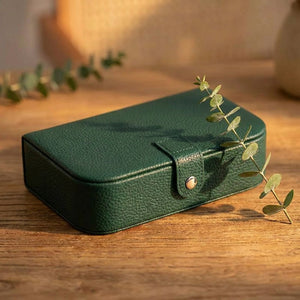 Boîte à bijoux voyage vert foncé en simili cuir grainé sur surface en bois