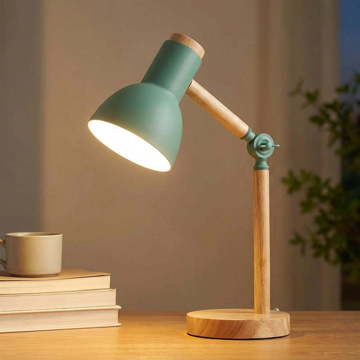 Lampe de bureau en bois clair à tête orientable verte allumée sur un bureau près de livres