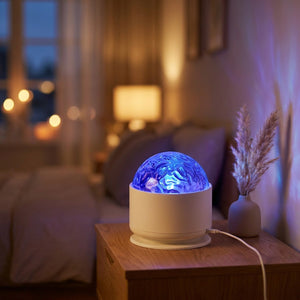 Veilleuse projecteur galaxie allumée en bleu sur une table de nuit en bois dans une chambre chaleureuse