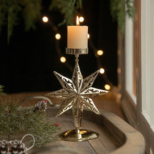 Chandelier de Noël en métal doré à motif étoile avec bougie allumée sur un plateau en bois