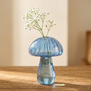Vase soliflore champignon en verre bleu avec fleurs séchées sur surface en bois