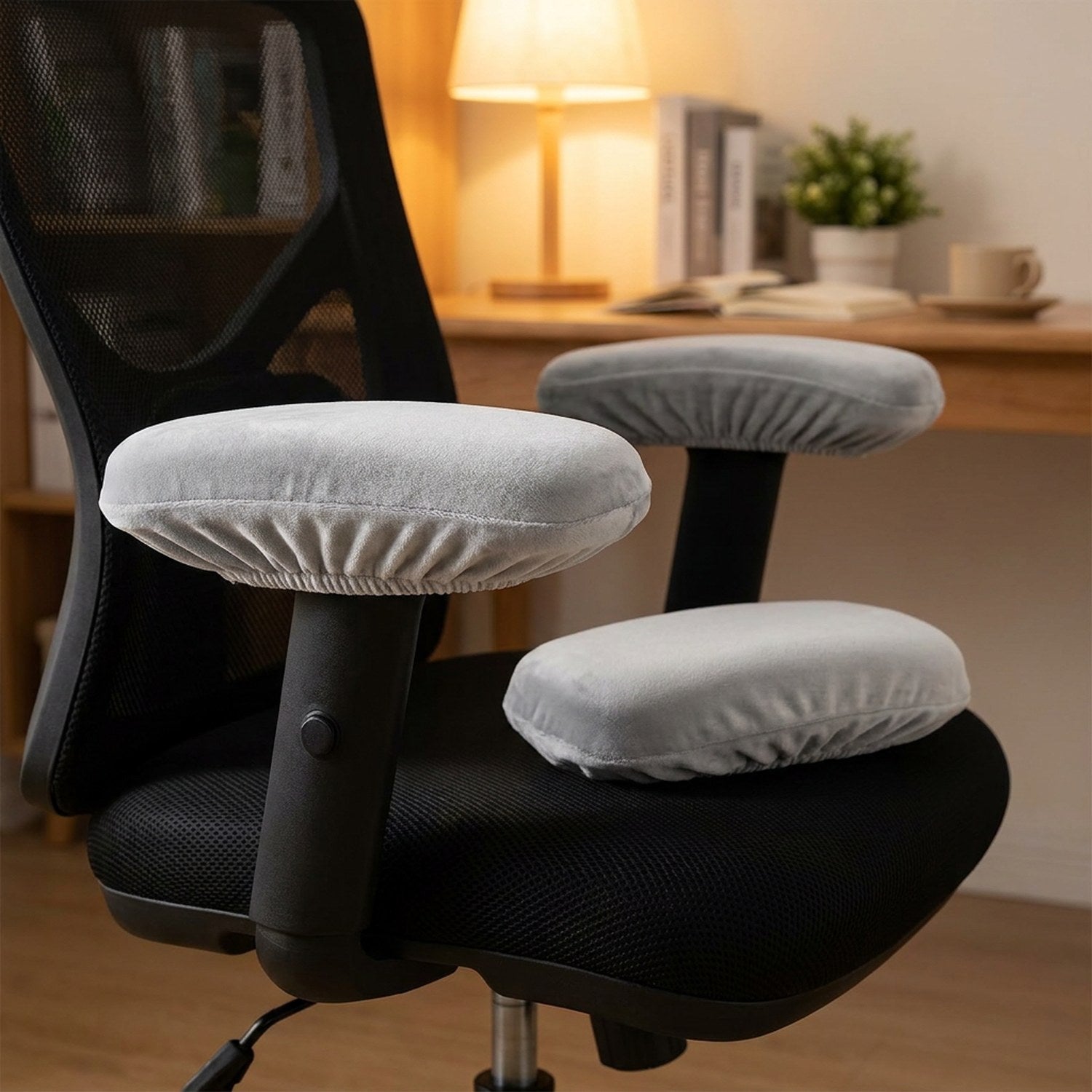 Housse d'accoudoir en velours gris clair installée sur l'accoudoir noir d'une chaise de bureau