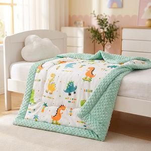 Couette bébé motif dinosaures colorée posée sur un lit d'enfant douillet