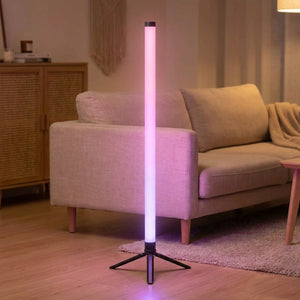 Lampe de sol RGB d'angle au tube dépoli allumée dans un salon scandinave