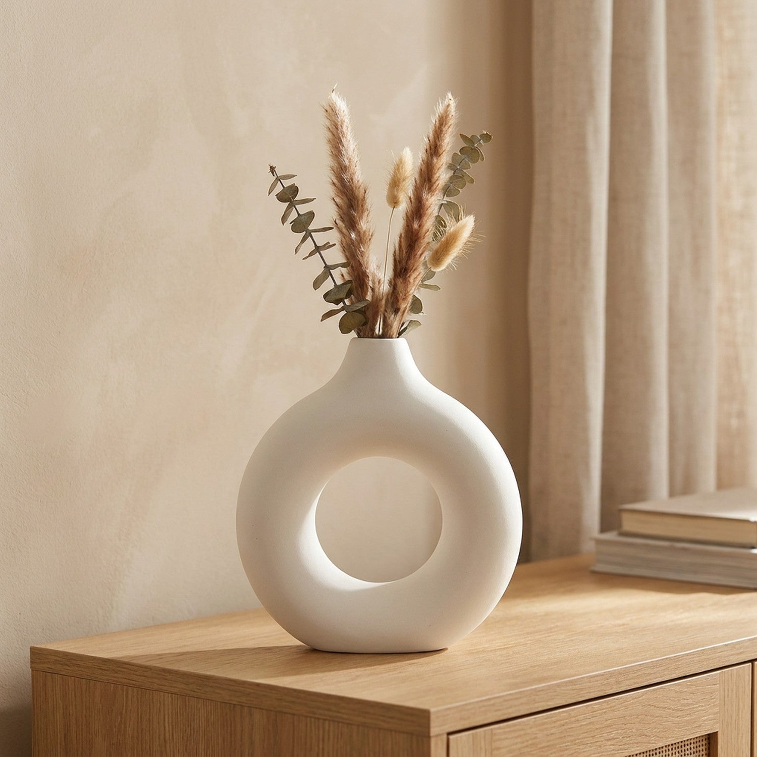 Vase à fleurs anneau blanc au design scandinave avec pampa séchée posé sur une console en bois