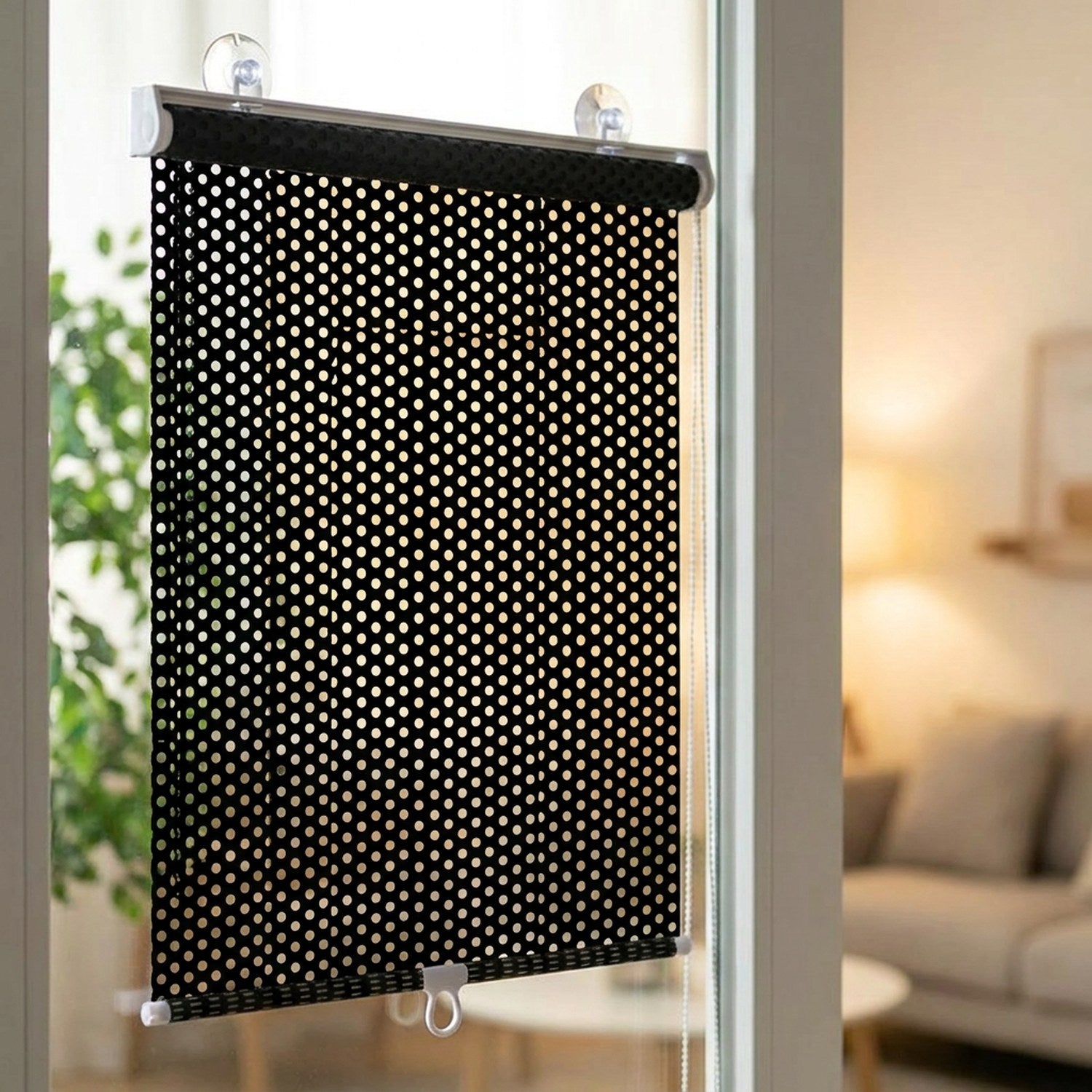 Store enrouleur noir occultant fixé par ventouses sur une fenêtre de chambre lumineuse