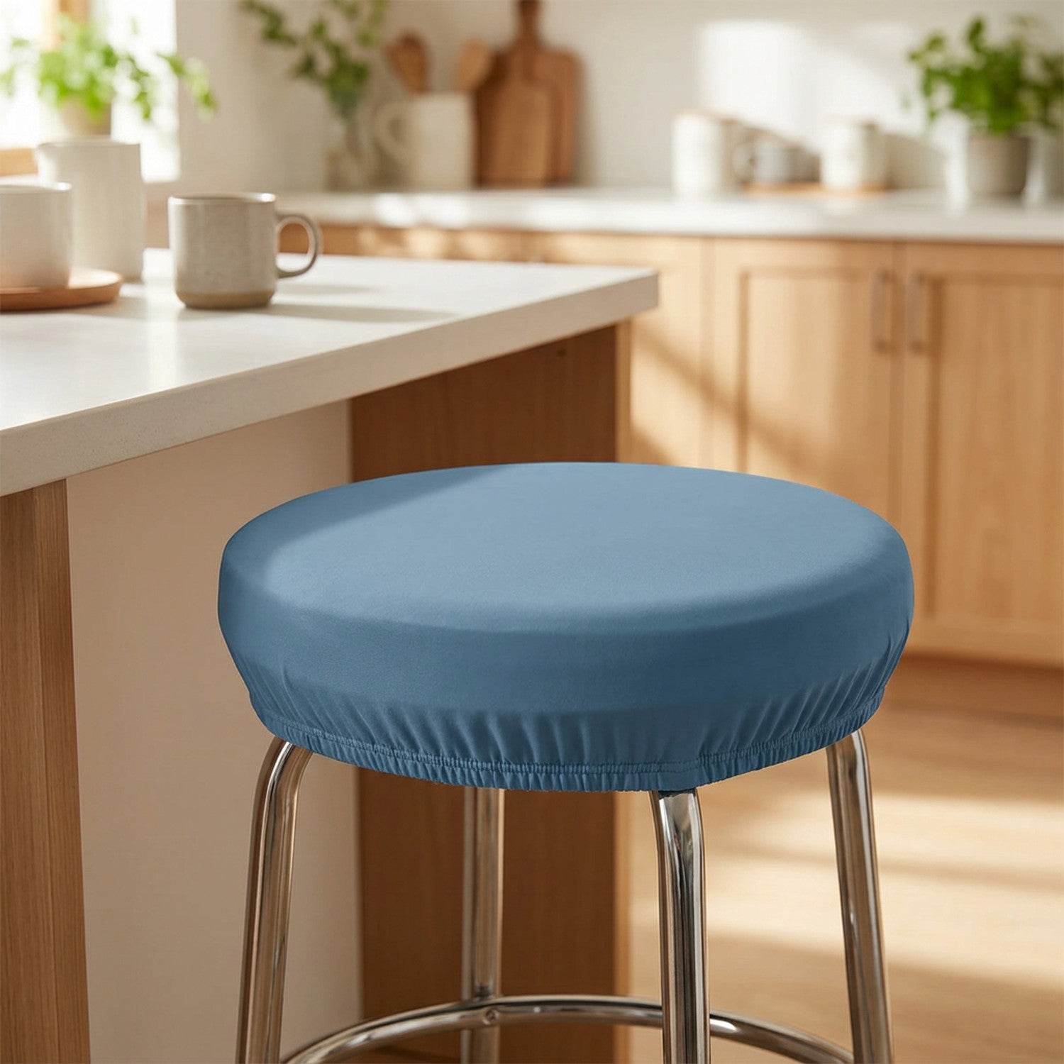 Housse de tabouret ronde élastique bleue posée sur un tabouret de bar dans une cuisine lumineuse