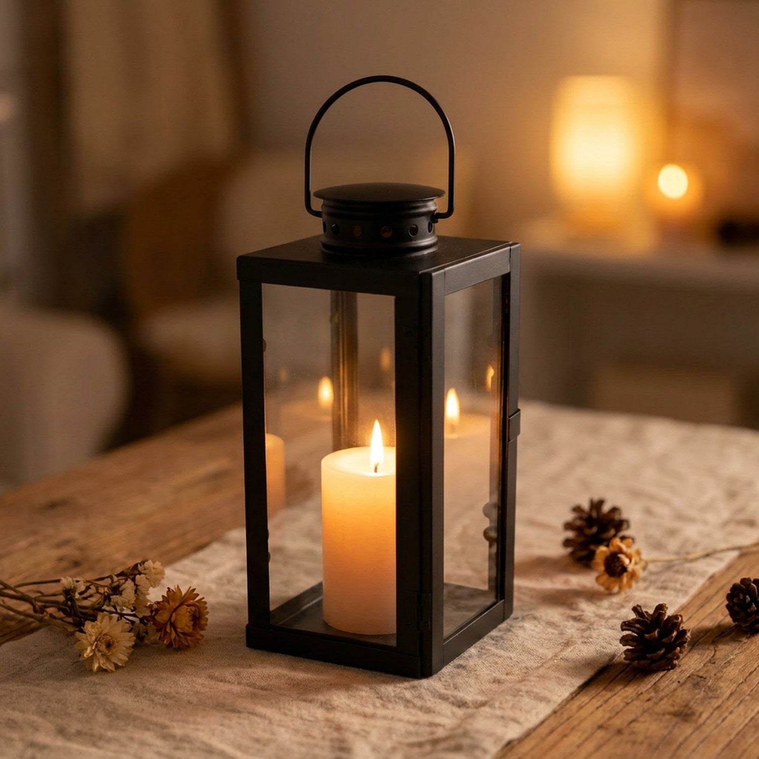 Lanterne à bougie en métal noir avec bougie allumée posée sur une table en bois dans un salon chaleureux