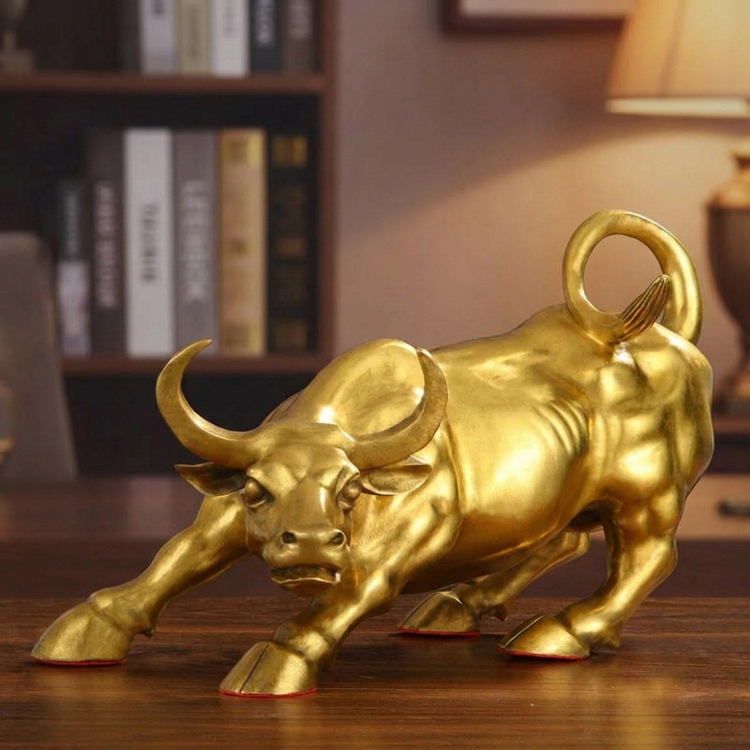 Statue taureau de Wall Street en laiton doré posée sur un bureau en bois sombre