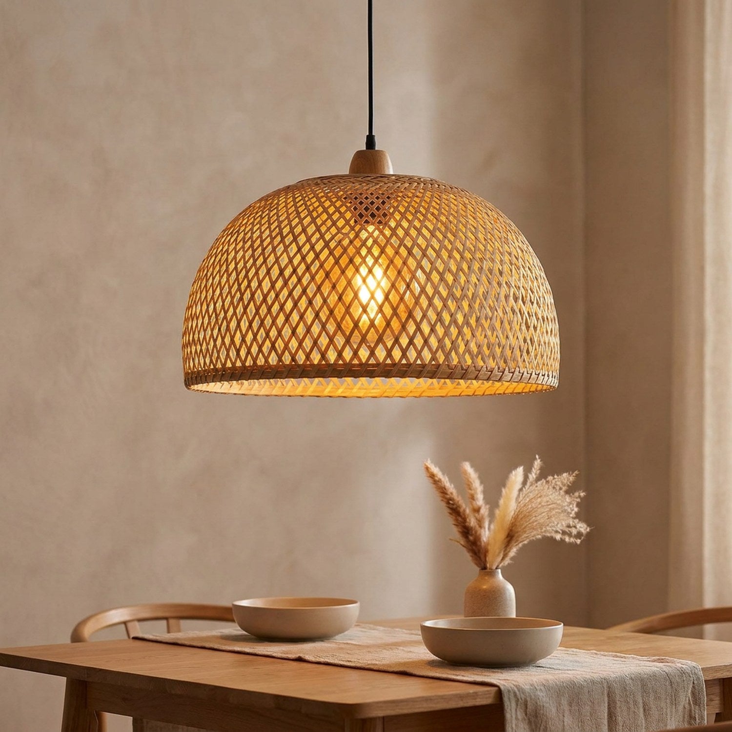 Suspension en bambou tressé naturel allumée au-dessus d'une table dans un intérieur chaleureux