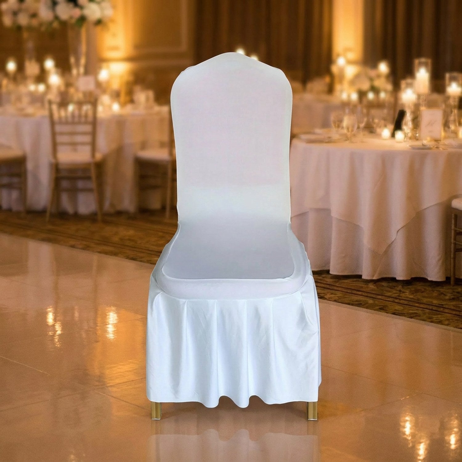 Rangée de chaises habillées de housses blanches dans une salle de réception de mariage