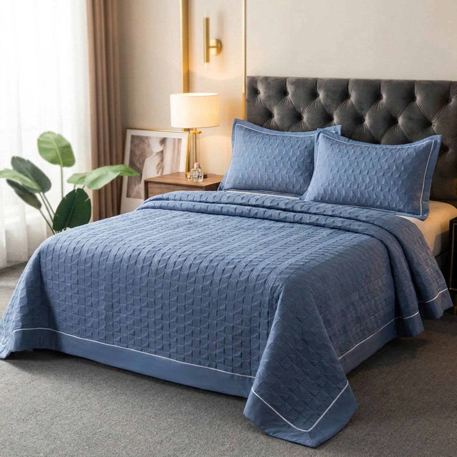 Couvre-lit matelassé bleu avec deux taies assorties sur un lit dans une chambre élégante