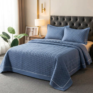 Couvre-lit matelassé bleu avec deux taies assorties sur un lit dans une chambre élégante
