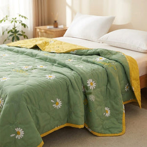 Couvre-lit d'été matelassé à motif marguerites sur un lit dans une chambre lumineuse