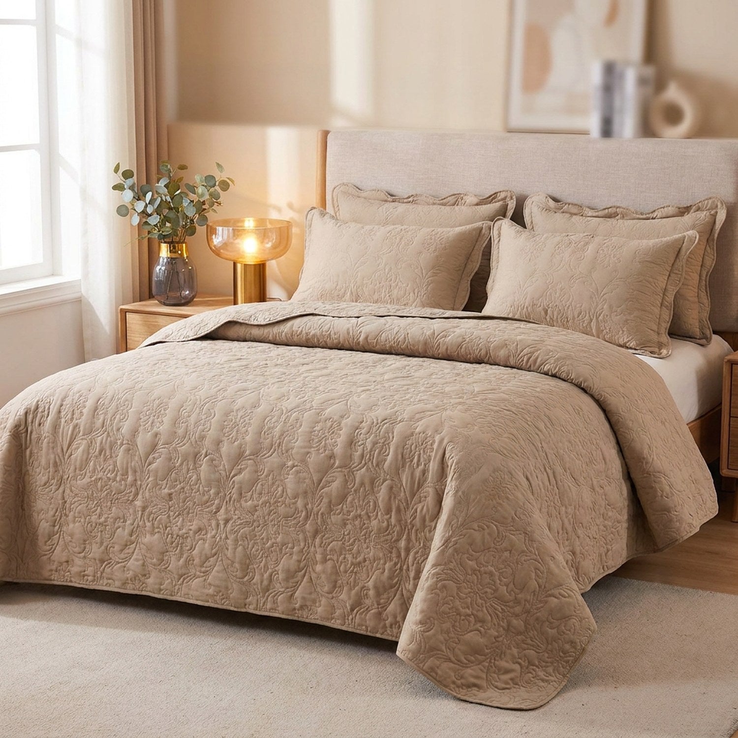 Couvre-lit matelassé beige au motif damassé en relief installé sur un lit avec deux taies assorties dans une chambre chaleureuse