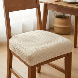 Housse de siège de chaise imperméable beige installée sur une chaise en bois dans une salle à manger
