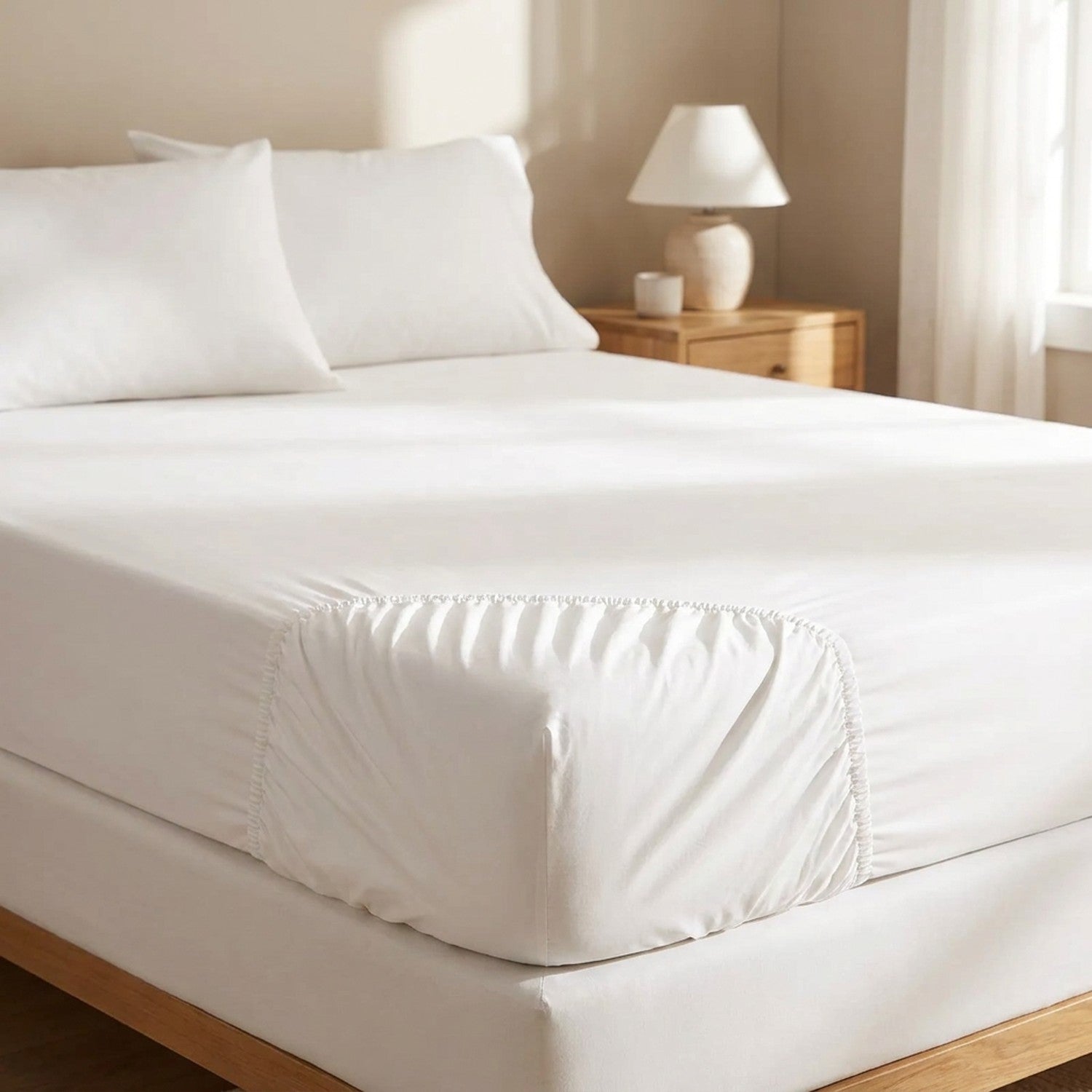 Drap-housse en coton égyptien blanc installé sur un lit dans une chambre lumineuse