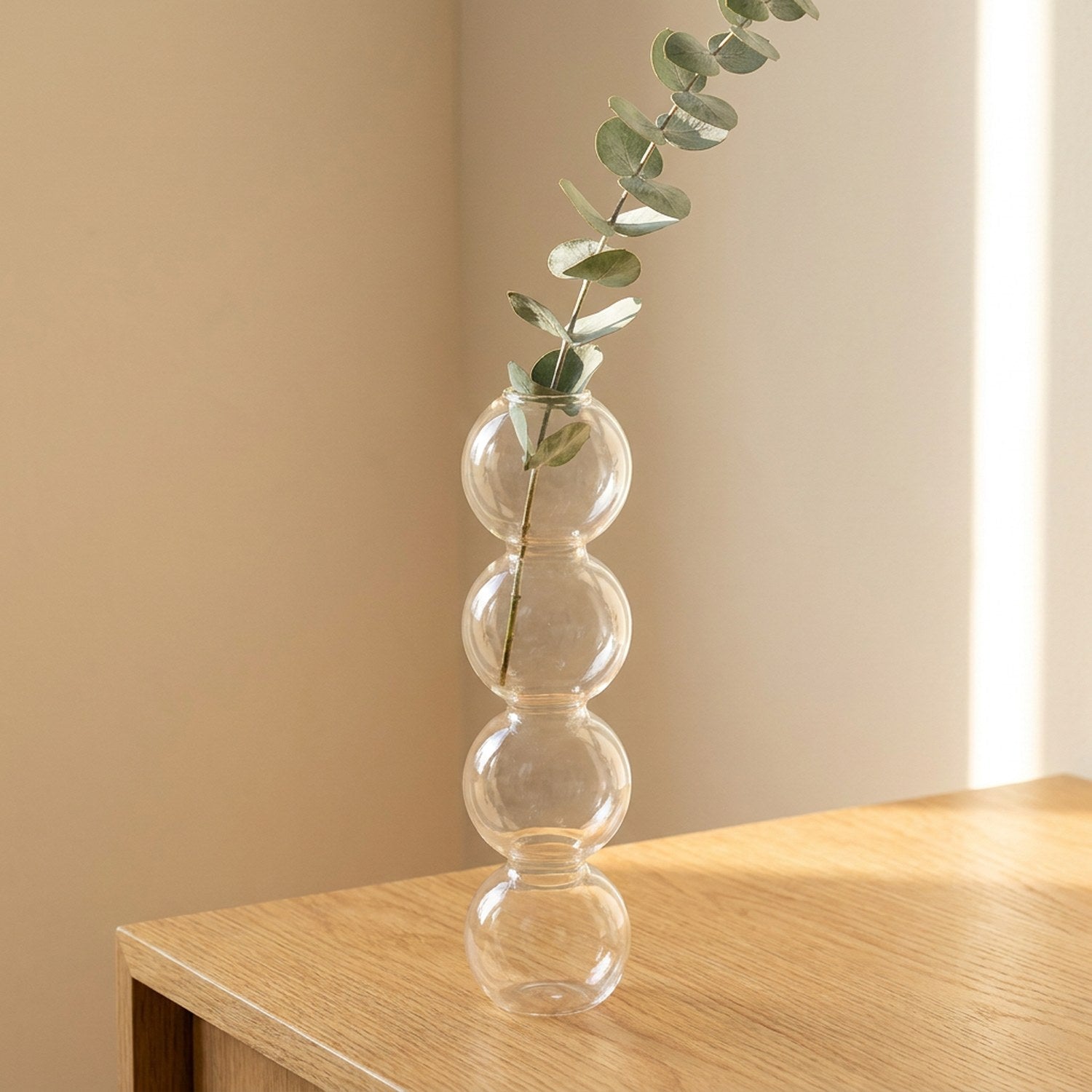 Vase en verre transparent style nordique avec branches d'eucalyptus sur tablette en bois chêne