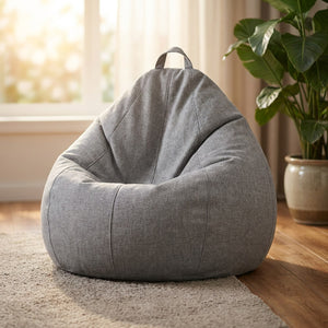 Pouf poire en lin gris chiné de forme goutte posé dans un salon lumineux