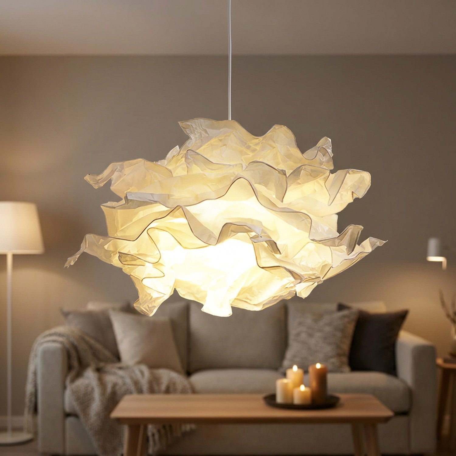 Abat-jour nuage en papier froissé blanc suspendu et allumé dans un salon cosy