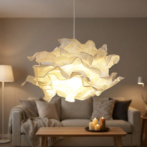 Abat-jour nuage en papier froissé blanc suspendu et allumé dans un salon cosy
