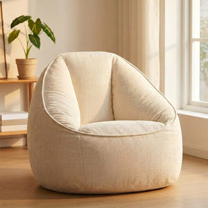 Fauteuil pouf rond en velours côtelé blanc dans un salon chaleureux avec plante