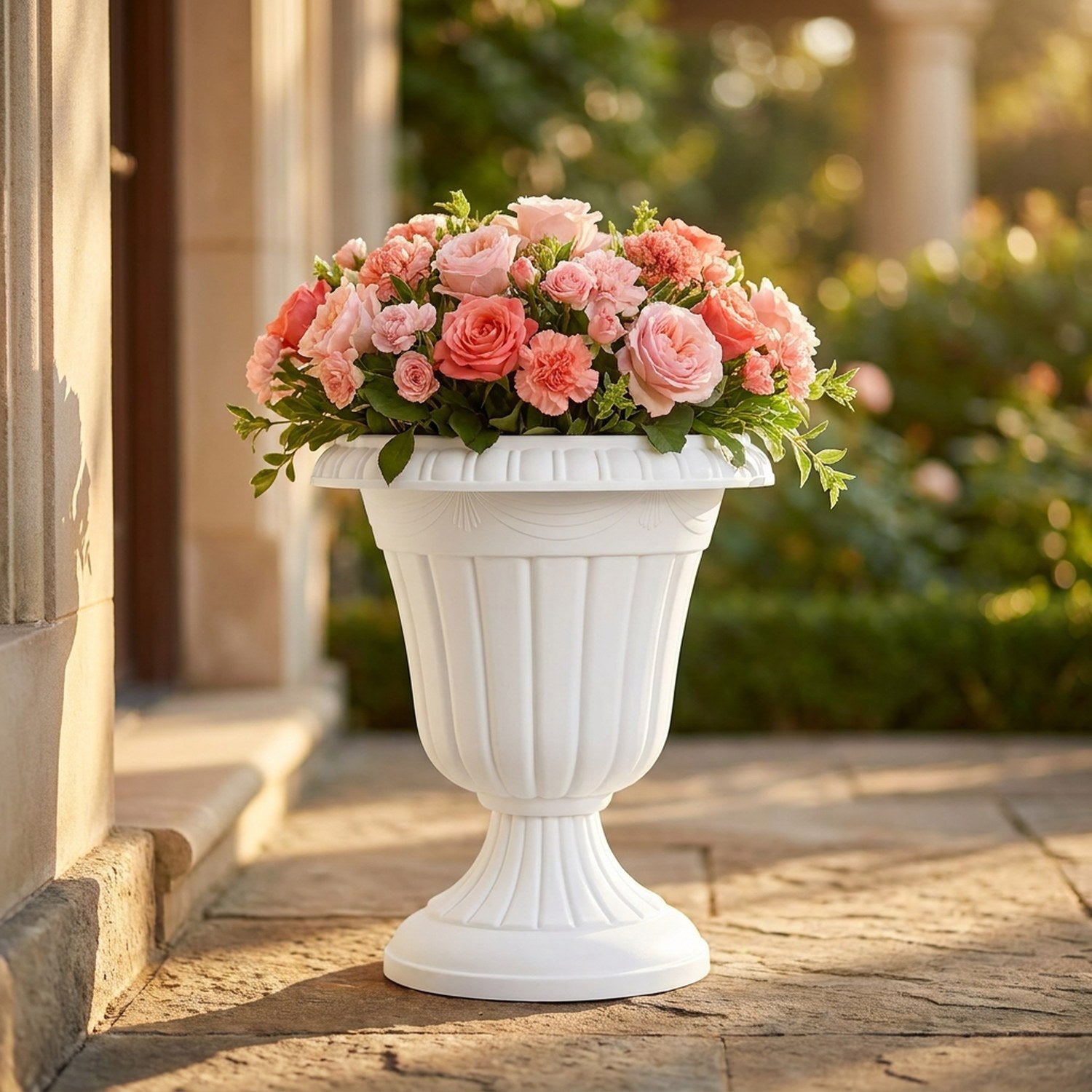 Grand pot de fleurs colonne romaine blanc garni de roses sur une terrasse ensoleillée