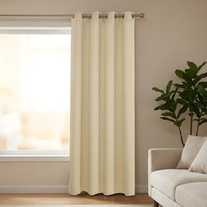 Rideau isolant thermique beige à œillets suspendu devant une fenêtre avec doublure matelassée visible