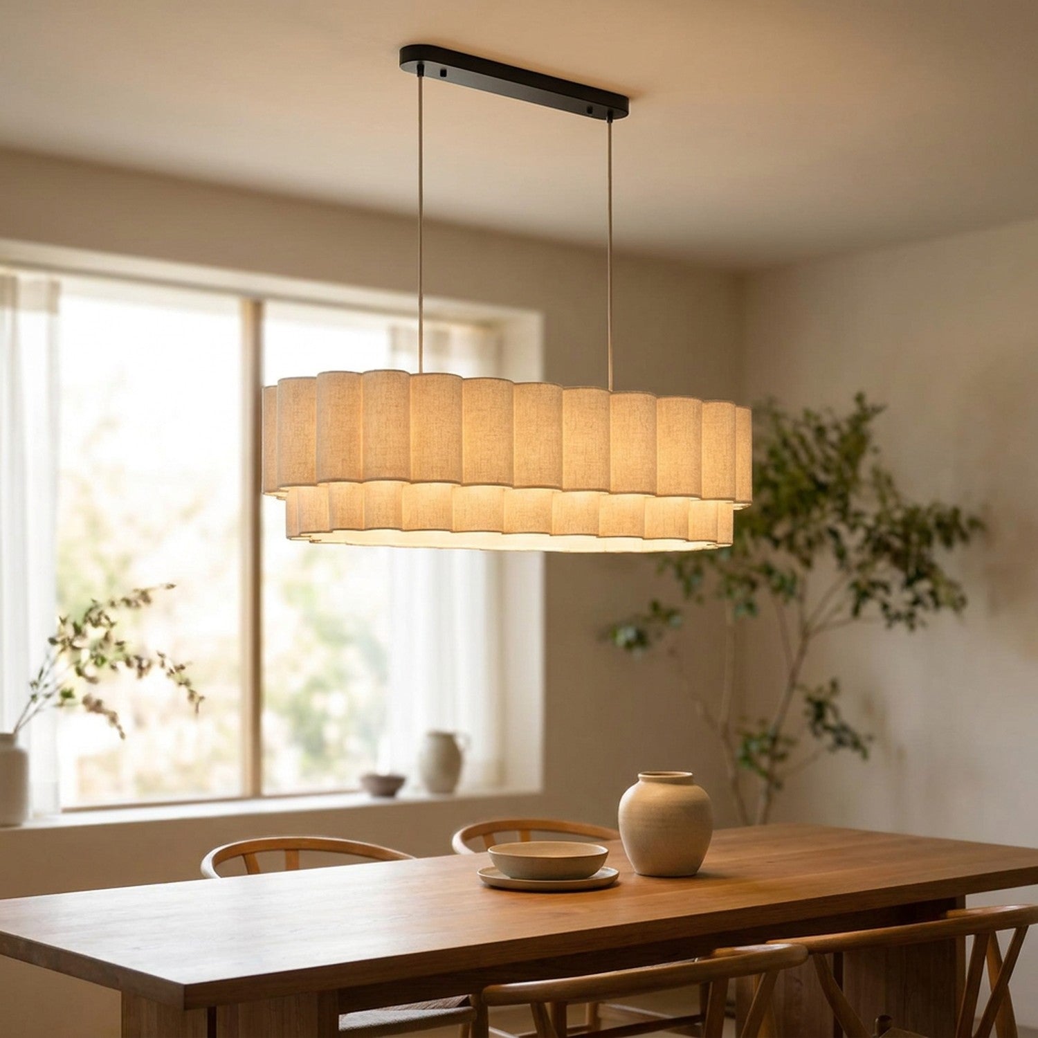 Suspension linéaire en tissu beige plissé allumée au-dessus d'une grande table à manger