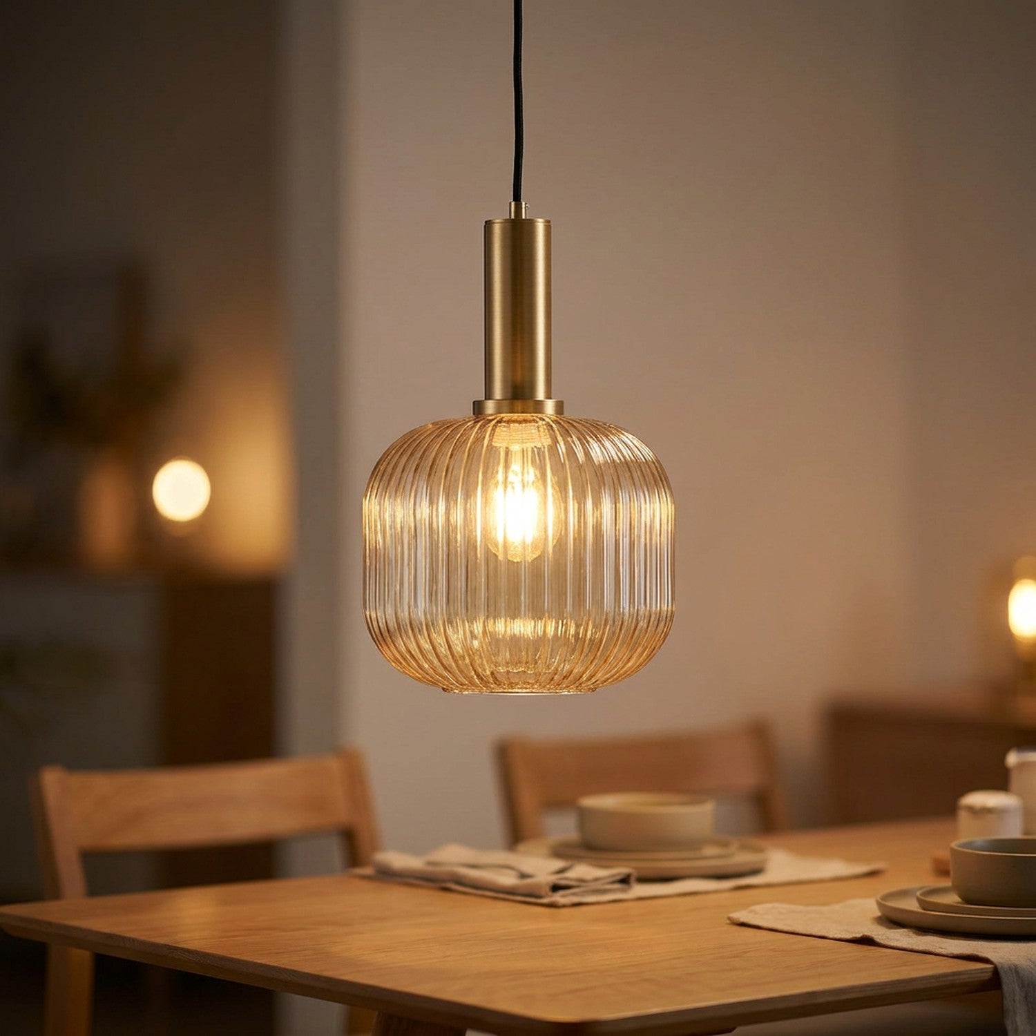 Suspension en verre ambré texturé et laiton doré éclairée au dessus d'une table à manger