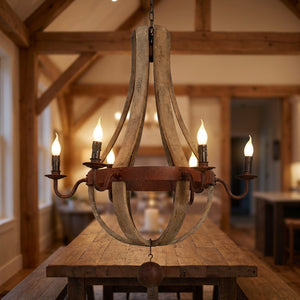 Lustre vintage en bois et métal en forme de tonneau avec lampes bougie allumées suspendu au-dessus d'une table