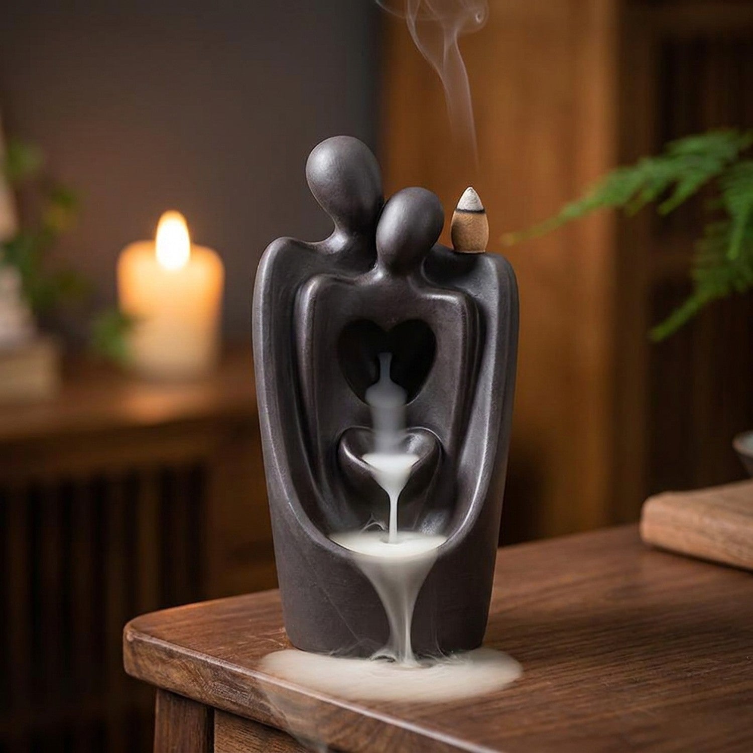 Brûleur d'encens à reflux en céramique anthracite représentant un couple enlacé avec une cascade de fumée blanche
