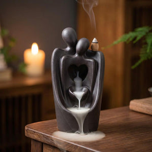 Brûleur d'encens à reflux en céramique anthracite représentant un couple enlacé avec une cascade de fumée blanche