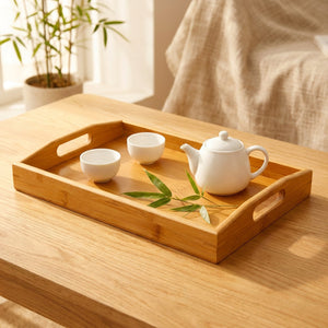 Plateau à thé en bambou naturel posé sur une table en bois avec théière et tasses à thé