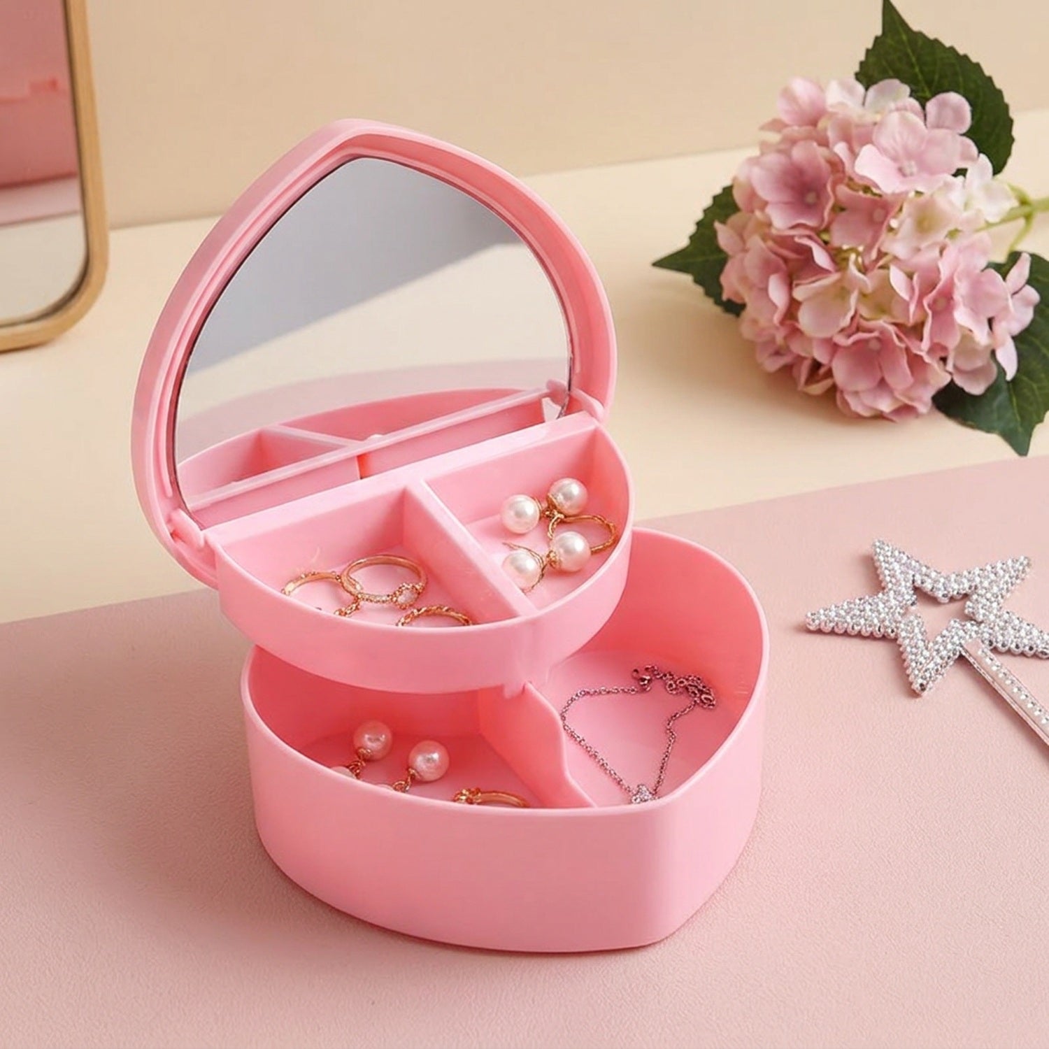 Boîte à bijoux cœur rose ouverte avec miroir sur coiffeuse