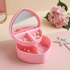 Boîte à bijoux cœur rose ouverte avec miroir sur coiffeuse