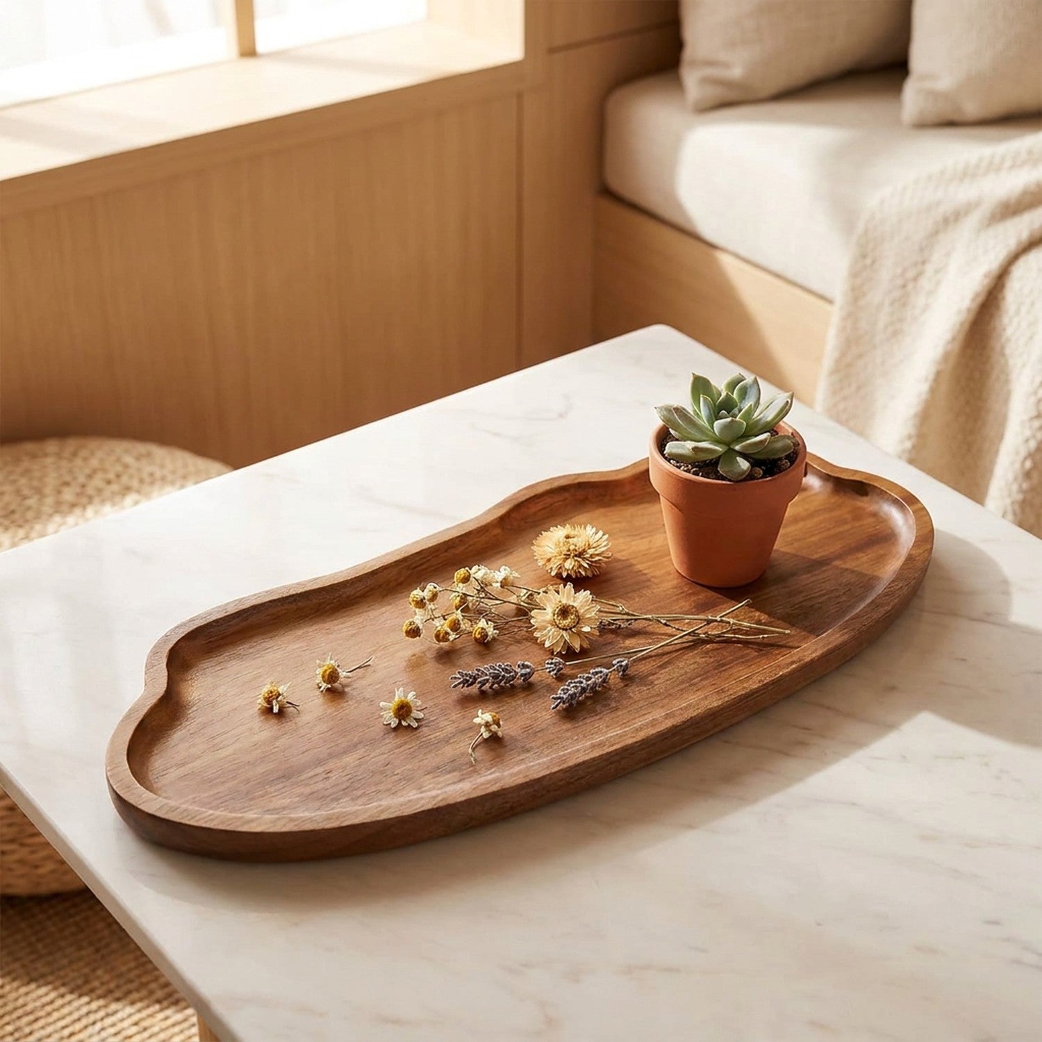 Plateau décoratif en bois organique aux bords naturels avec fleurs séchées sur table en marbre dans un intérieur japandi